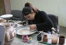 Ceramics Artisan * A worker at a workshop for handicapped artisans.  This young lady is creating a faux-mosaic pattern on a bowl, a common style used in Jordanian ceramics. * 432 x 294 * (58KB)
